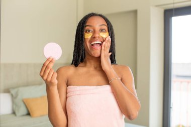 Siyah afro kadın kendini mutlu hissediyor ve inanılmaz bir şeye hayret ediyor. güzellik konsepti