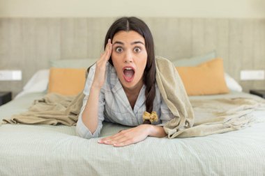 Oldukça genç bir model mutlu, şaşkın ve şaşırmış görünüyor. dinlenme ve gecelik konsepti