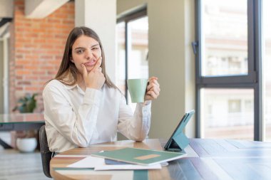 young pretty woman with mouth and eyes wide open and hand on chin. telecommuting concept