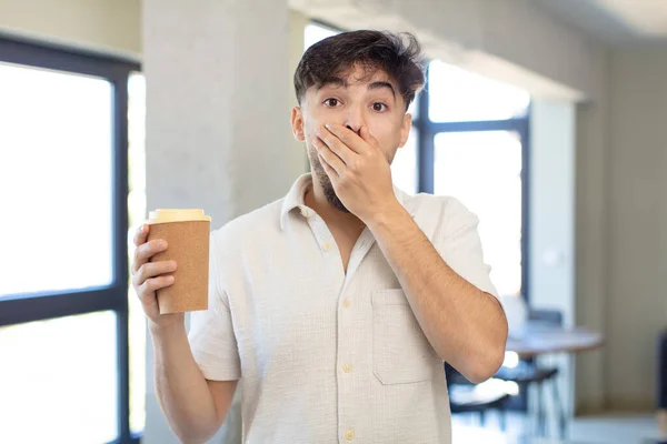 若いハンサムな男が手で口をカバーし ショックや驚きの表情 コーヒーの概念を取り上げ — ストック写真