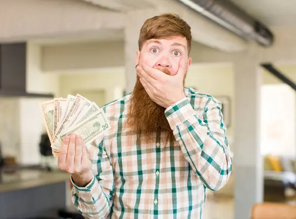 红头发男人用手捂住嘴 用美元钞票震惊或惊讶地表情 — 图库照片