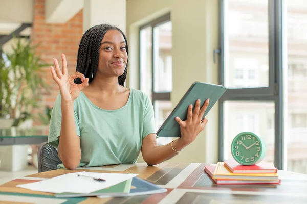 stock image black afro woman feeling happy, showing approval with okay gesture. studying concept