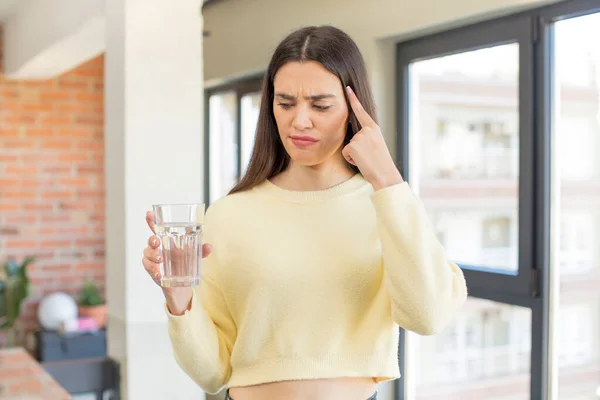 stock image pretty young model looking surprised, realizing a new thought, idea or concept. water glass concept