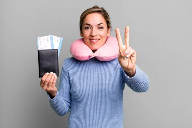 Güzel sarışın kadın gülümsüyor ve arkadaş canlısı görünüyor. İki numarayı gösteriyor. uçuş yolcu kavramı