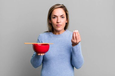 Güzel sarışın kadın kapiş ya da para hareketi yapıyor, sana ödemeni söylüyor. Japon eriştesi konsepti