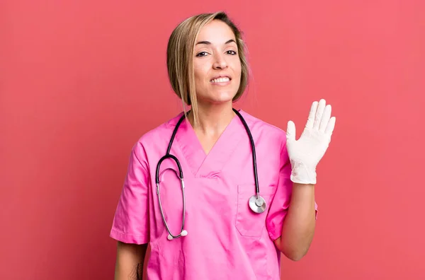 Mooie Blonde Vrouw Glimlachend Gelukkig Zwaaiende Hand Verwelkomen Groeten Verpleegkundig — Stockfoto