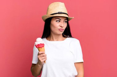 Hispanik güzel kadın üzgün, üzgün ya da kızgın hissediyor ve yana bakıyor. dondurma ve yaz konsepti