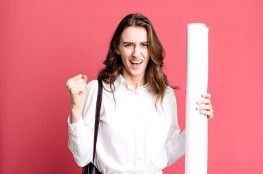 young pretty woman shouting aggressively with an angry expression. architect concept