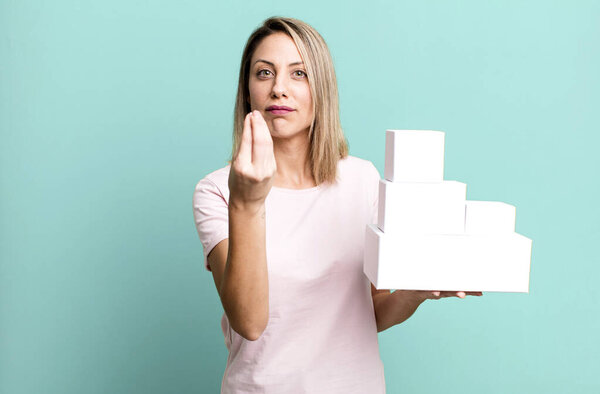 pretty blonde woman making capice or money gesture, telling you to pay with a set of blank packagings