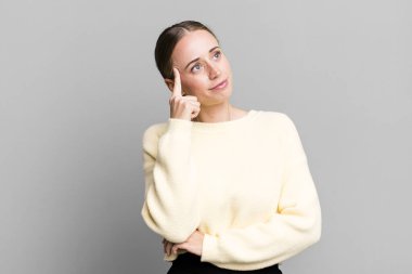 Yoğunlaşmış bir bakışla, şüpheli bir ifadeyle, yukarı ve yana bakarak