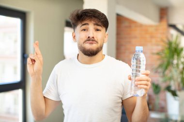 Genç yakışıklı adam şans diliyor ve şans diliyor. su şişesi kavramı