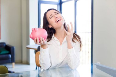 young adult pretty woman with a piggy bank. money and savings concept