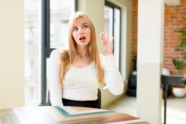 Genç ve güzel bir kadın ciddi ve meraklı görünüyor, dinliyor, gizli bir konuşma veya dedikodu duymaya çalışıyor, kulak misafiri oluyor. ev içi