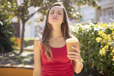 pretty woman feeling sad and whiney with an unhappy look and crying. take away coffee concept
