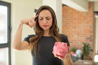 Güzel kadın şaşırmış görünüyor, yeni bir düşünce, fikir ya da konsept fark ediyor. Domuz kumbarası