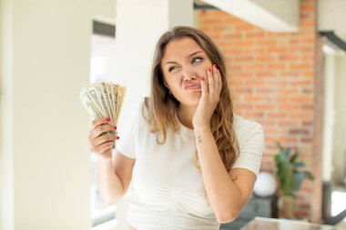 pretty woman feeling bored, frustrated and sleepy after a tiresome. dollar banknotes concept