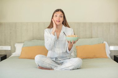 Genç ve güzel bir kadın inanılmaz bir şey karşısında kendini mutlu ve şaşkın hissediyor. kahvaltı kavramı