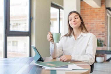 Genç ve güzel bir kadın gülümsüyor ve kendine güveni tam bir ifadeyle bakıyor. Evden işe dolaşma kavramı