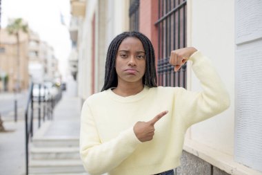 Afro güzel siyah kadın mutlu, tatmin olmuş ve güçlü hissediyor, kaslı ve formda, spor salonundan sonra güçlü görünüyor.