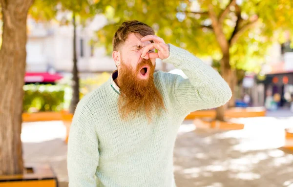 Рыжеволосый Бородатый Мужчина Чувствует Отвращение Держа Нос Избежать Неприятного Запаха — стоковое фото