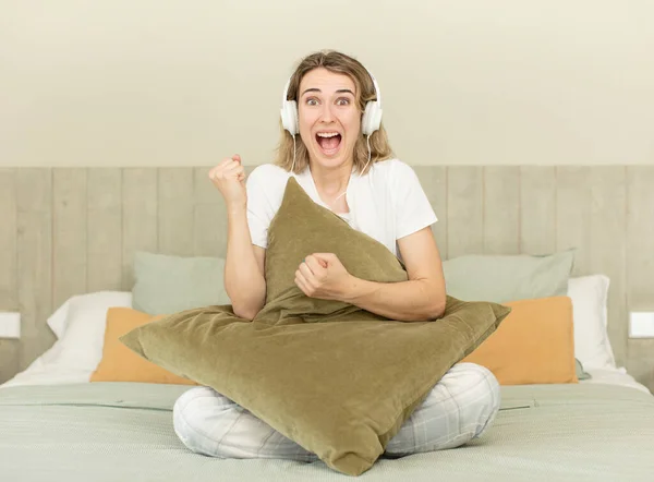 stock image pretty woman feeling shocked,laughing and celebrating success. nightwear and bedroom concept