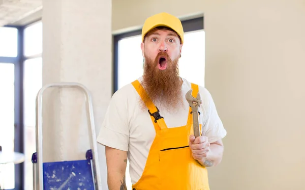 赤い髪の男は非常にショックを受け 自宅を修復驚いている 便利屋のコンセプト — ストック写真