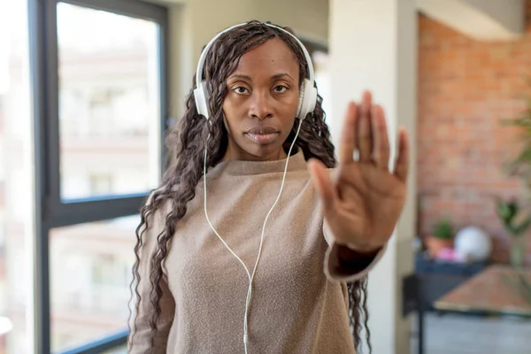 黑人非洲女人看起来严肃地表现出开放的手心制作停止手势 听音乐的概念 — 图库照片