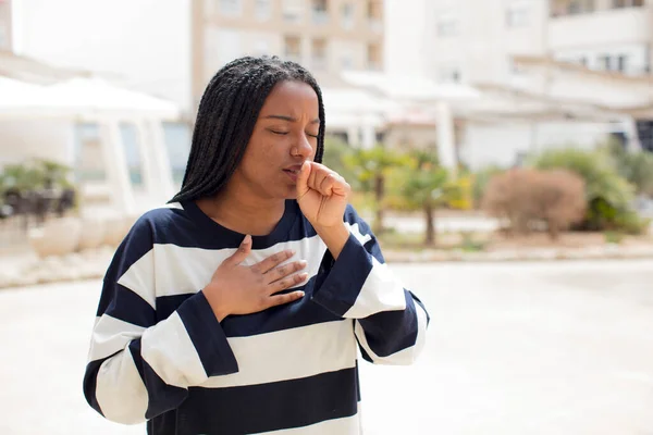 アフリカの黒人女性は喉の痛みやインフルエンザの症状で気分が悪く口を覆い咳をし — ストック写真
