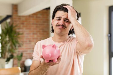 Kumbaralı genç ve yakışıklı bir adam. ev içi tasarruf kavramı