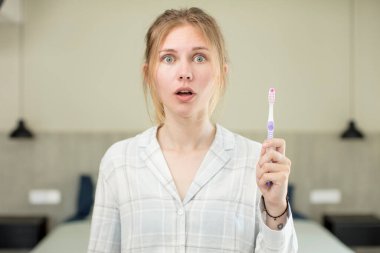 Genç ve güzel bir kadın şok olmuş ve şaşırmış hissediyor. diş yıkama kavramı