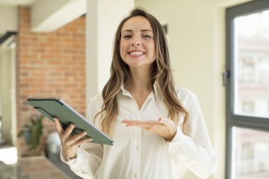 Güzel bir kadın neşeyle gülümser, mutlu hisseder ve bir konsept gösterir. dokunmatik ekran konsepti. dokunmatik ekran konsepti