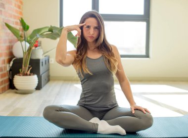 Güzel kadın şaşırmış görünüyor, yeni bir düşünce, fikir ya da konsept fark ediyor. yoga mat konsepti