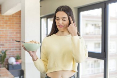 Oldukça genç bir model şaşırmış görünüyor, yeni bir düşünceyi, fikri ya da konsepti fark ediyor. Kahvaltı kasesi konsepti