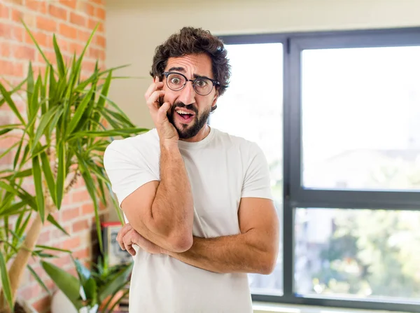 young adult crazy man with expressive pose at a modern house interior