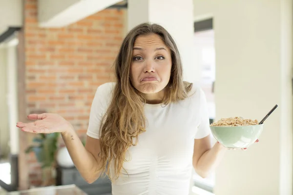 stock image pretty woman shrugging, feeling confused and uncertain. breakfast bowl concept