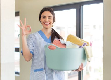 Oldukça genç bir model kendini mutlu hissediyor. Onayını iyi bir hareketle gösteriyor. Temizlikçi ve çamaşır konsepti