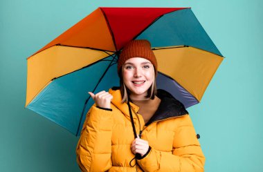 young pretty woman wearing an anorak and a umbrella