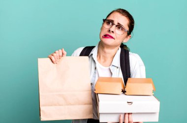 Fast food kutuları getiren genç ve güzel bir kadın.