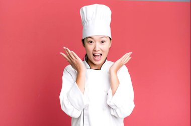 Güzel Asyalı bir kadın kendini mutlu hissediyor ve inanılmaz bir şeye hayret ediyor. restoran şefi konsepti