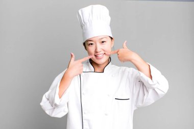 Güzel Asyalı kadın kendine güvenerek gülümsüyor. restoran şefi konsepti