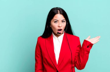 İspanyol güzel kadın şaşırmış ve şok olmuş görünüyor. Çenesi düşmüş ve elinde bir nesne var. tele pazarlama kavramı