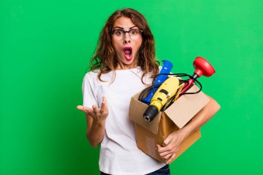 İspanyol güzel kadın bir alet çantasıyla şok olmuş ve şaşırmış hissediyor. Becerikli adam kavramı