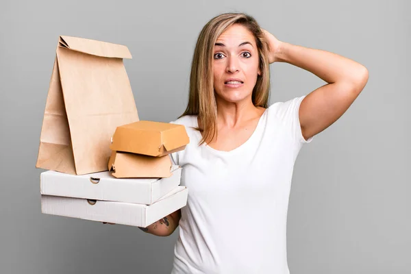 かなりブロンドの女性はストレスを感じ不安や恐怖を感じ手を頭の上に 配送は食品パッケージの概念を取り除き — ストック写真