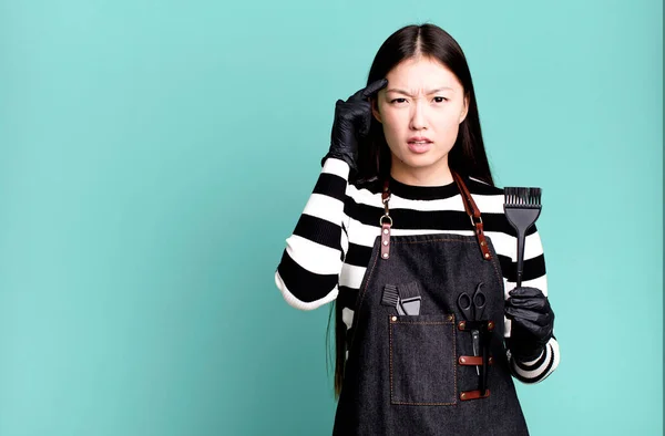 Stock image pretty asian woman feeling confused and puzzled, showing you are insane. barber concept