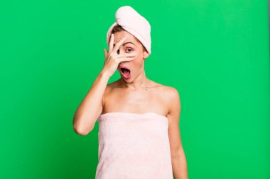 İspanyol görünümlü güzel bir kadın şok olmuş, korkmuş ya da dehşete düşmüş, elleri bornoz giymiş. güzellik konsepti