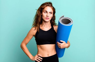 Hispanik güzel kadın üzgün, üzgün ya da kızgın hissediyor ve yana bakıyor. fitness ve yoga konsepti