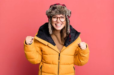 İspanyol güzel kadın şokta, gülüyor ve anorak giyerek başarıyı kutluyor. Soğuk ve kış kavramı