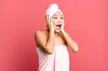 İspanyol güzel kadın mutlu, heyecanlı ve şaşırmış bornoz giyiyor. güzellik konsepti