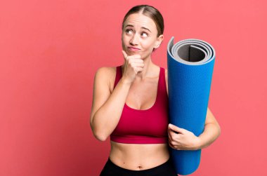 Kafkasyalı güzel kadın düşünüyor, kuşkulu ve şaşkın hissediyor. fitness ve yoga konsepti