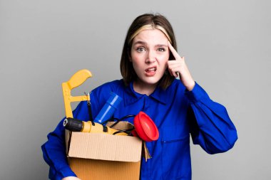 Genç ve güzel bir kadın kafası karışık ve şaşkın hissediyor, deli olduğunu gösteriyor. kahya ve alet çantası kavramı